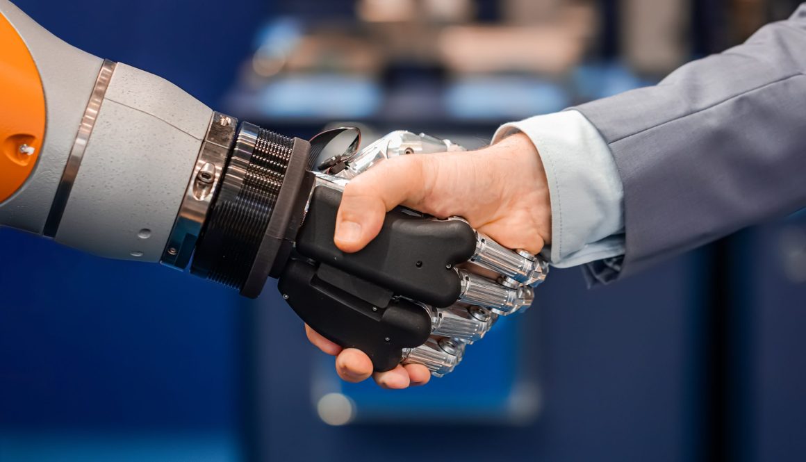 Hand of a businessman shaking hands with a Android robot.